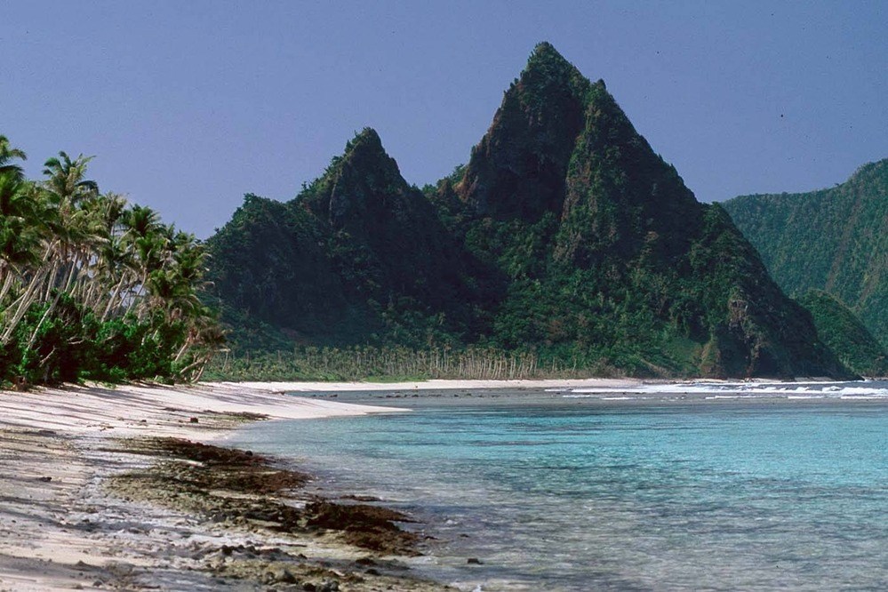 large tall mountains overlooking a sandy cove