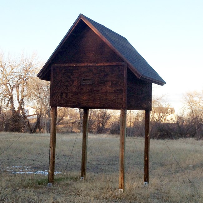 A wooden house-shaped structure on stilts