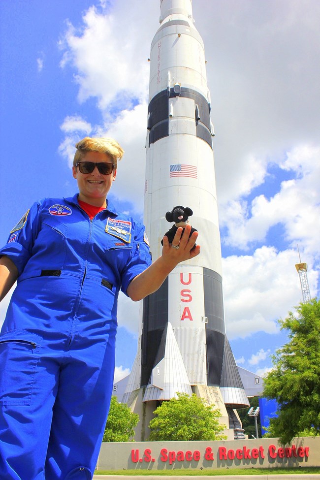 women holding toy dog in front of a rocket