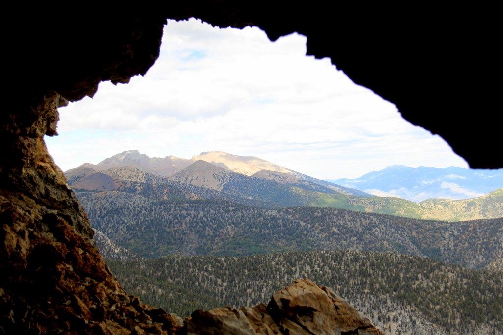 view out of cave opening, mountains and trees