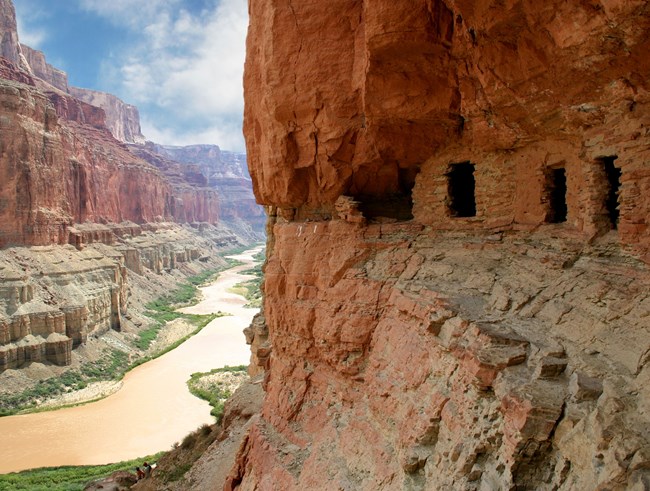 prehistoric granaries in canyon wall above river