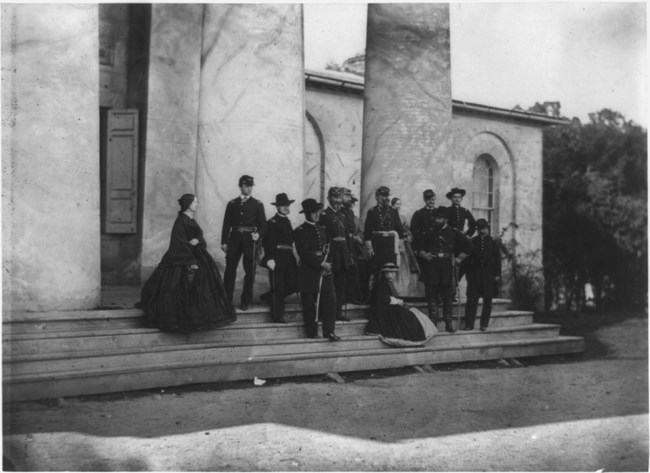 A general and his staff with their families pose before the great columns of Arlington House