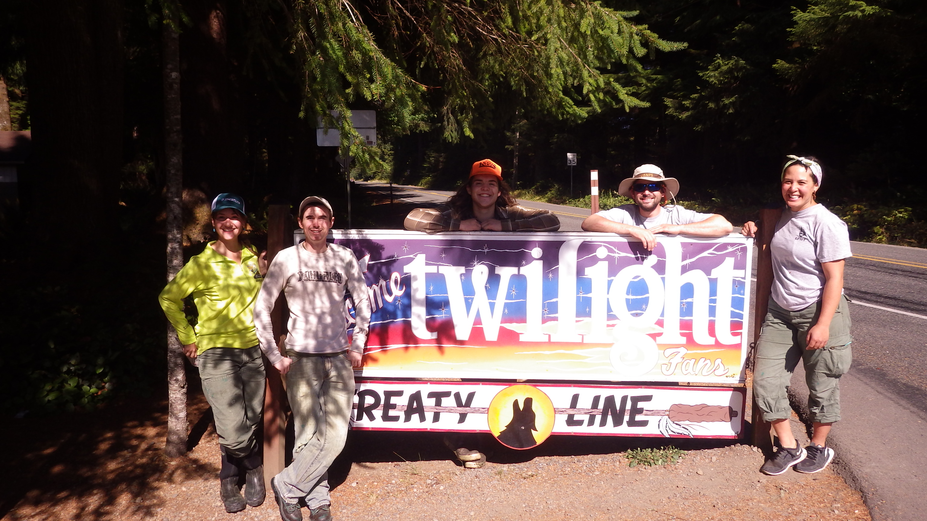 A group of people stand around a a sign reading "Twilight fans".