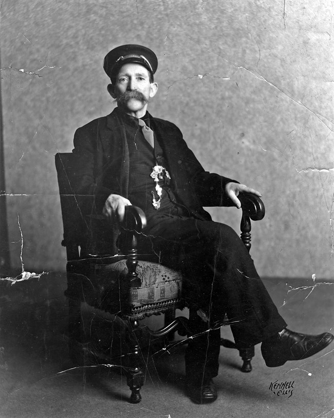 A well dressed man sitting in a chair