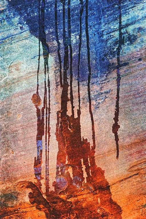 Water dripping down colorful rock.