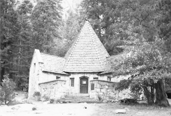 lodge with conical-shaped roof, surrounded by trees