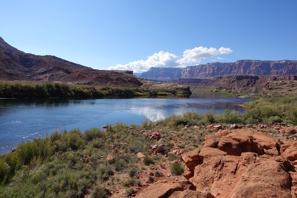 A scenic overview of a rocky shoreline with cliffs and a river in the background.