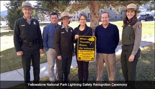 Park rangers and representatives from NOAA holding lightning safety sign