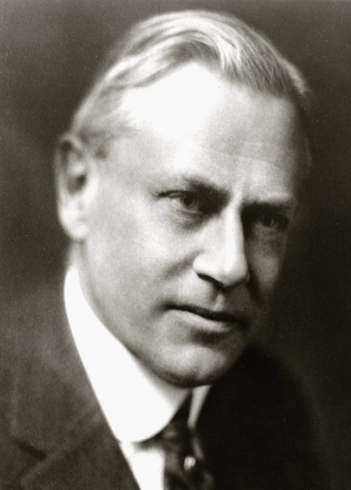 Bust of an older man with light gray hair in a suit.