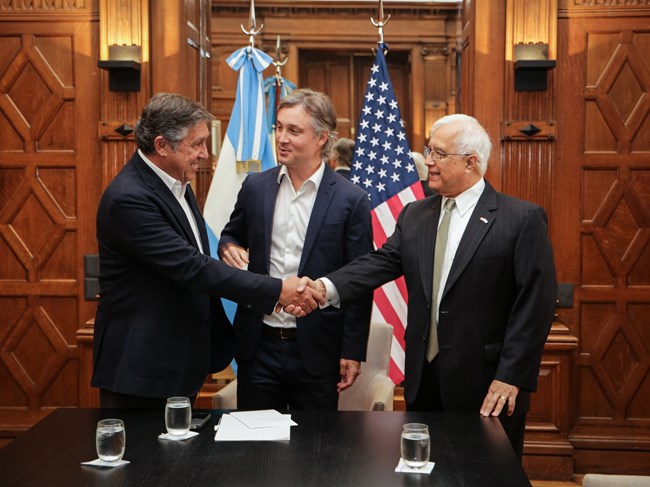 US and Argentina representatives shake hands after signing the MOU.