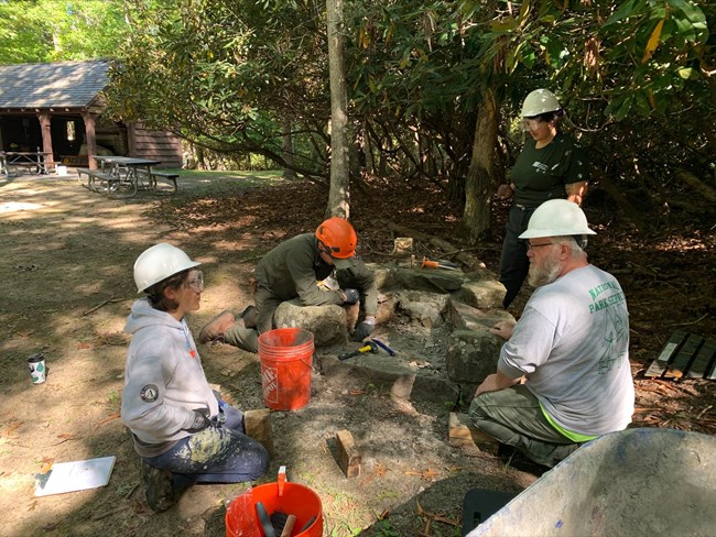 NPS Historic Preservation Training Center Mason Michael Weibush working with the NERI Trail Worker and AmerCorps Members on the repair of hearths at Grandview Shelter 1.