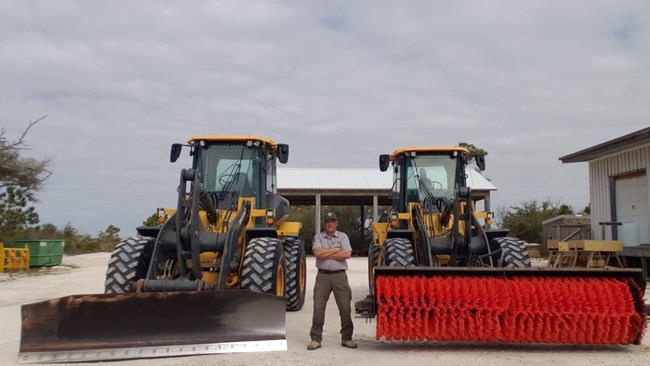 Garey Bickham between two large pieces of machinery
