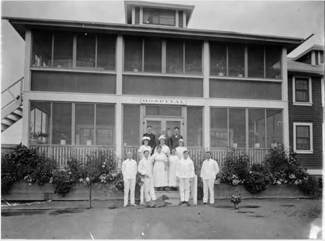 people standing outside a large two story building