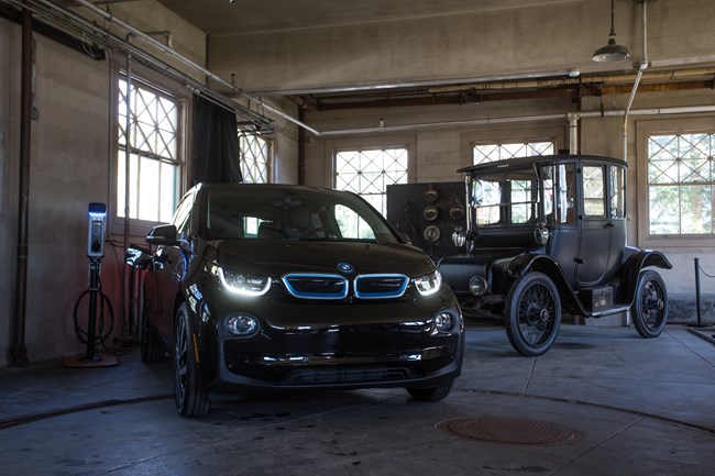 Modern electric vehicle manufactured by BMW (2017 i3) and Thomas Edison's 1917 Detroit Electric Model 47 and their charging stations inside Edison's Glenmont garage at Thomas Edison National Historical Park.