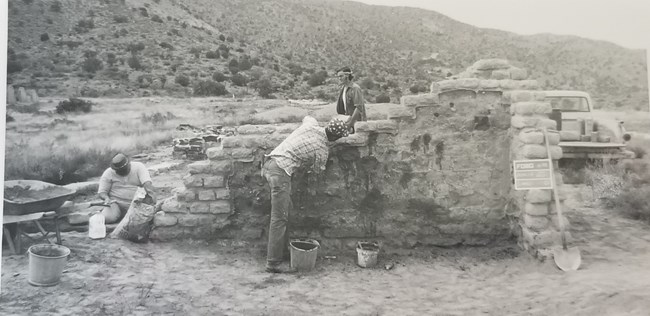 Three men complete stabilization efforts on the old hospital wall, 1973.