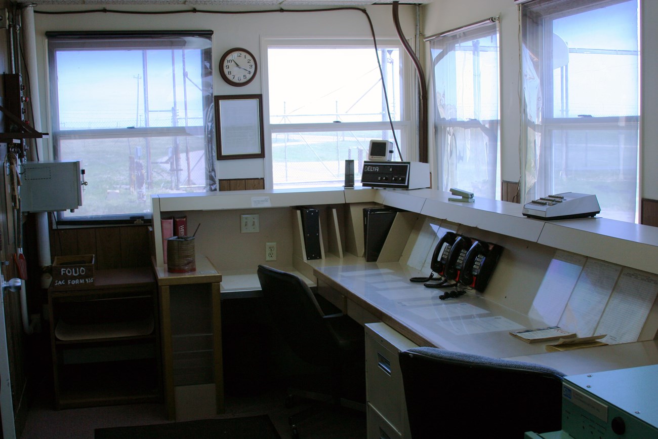 Office with a large console desk and many windows