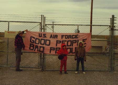 A group of people stand at a banner on a fence
