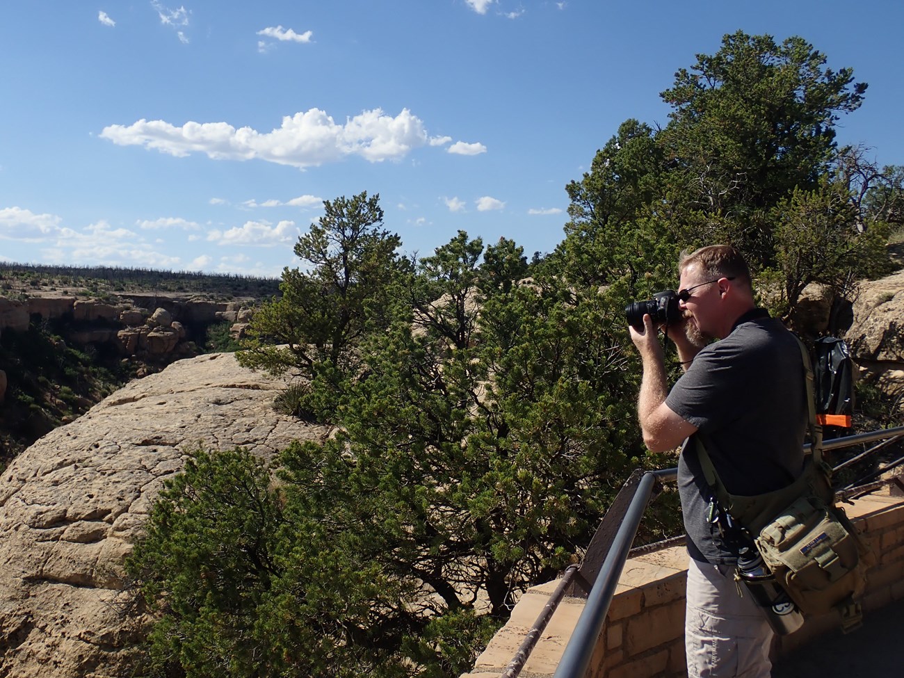 A man uses his camera to capture a scenic vista.
