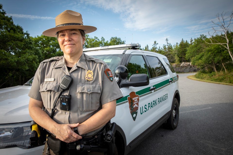 Ranger stands beside patrol vehicle