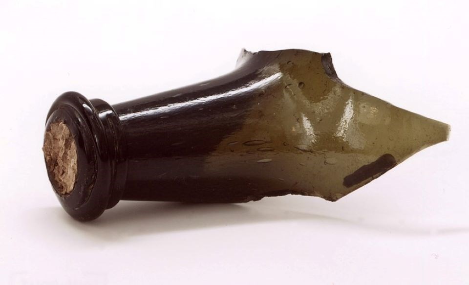 broken neck of a green glass wine bottle with cork