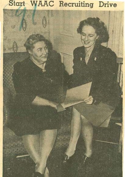 newspaper image showing two women sitting looking at a piece of paper