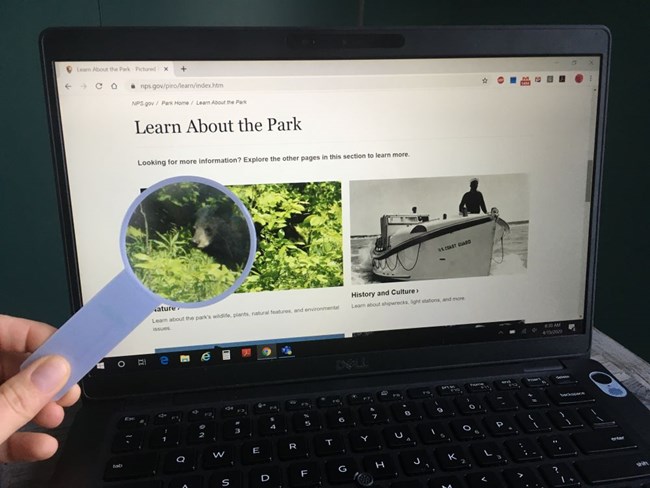 Laptop computer screen with Pictured Rocks National Lakeshore's 'Learn About the Park' page displayed on it