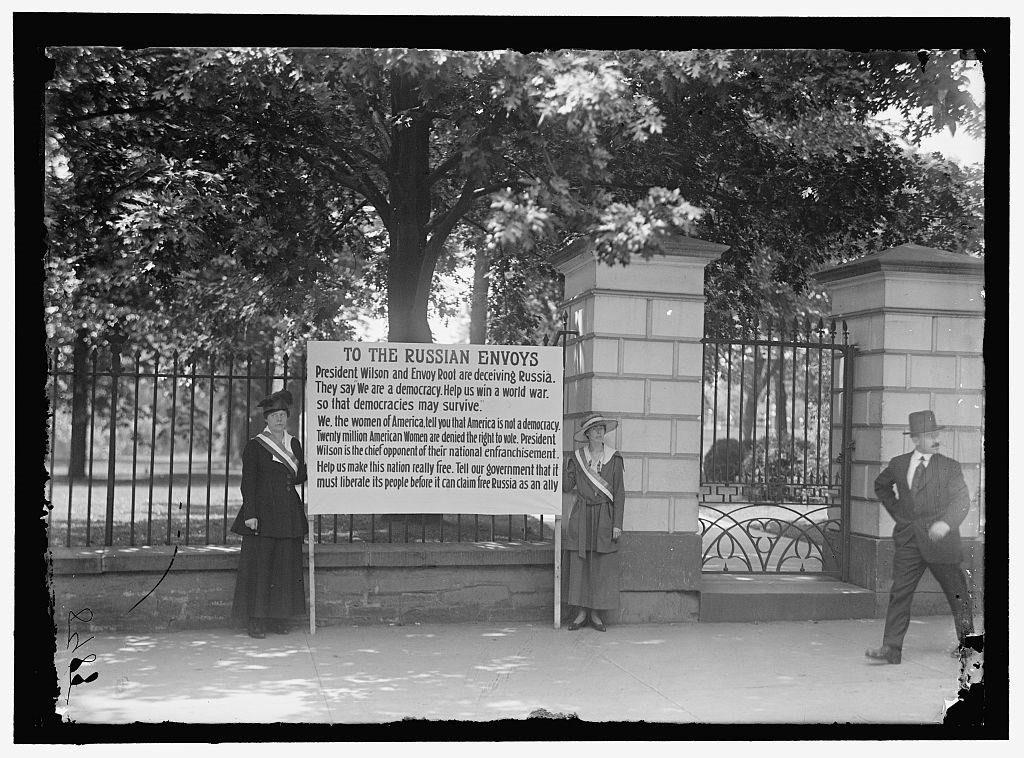 Suffragists standing with a banner