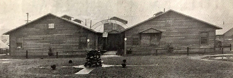 Black and white photo of a wooden building with a YMCA sign.