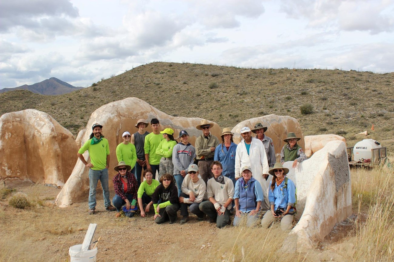 Field school participants, including students from the youth summit, pose for a photo in front of the ruins of the old Post Trader's store at Fort Bowie NHS.