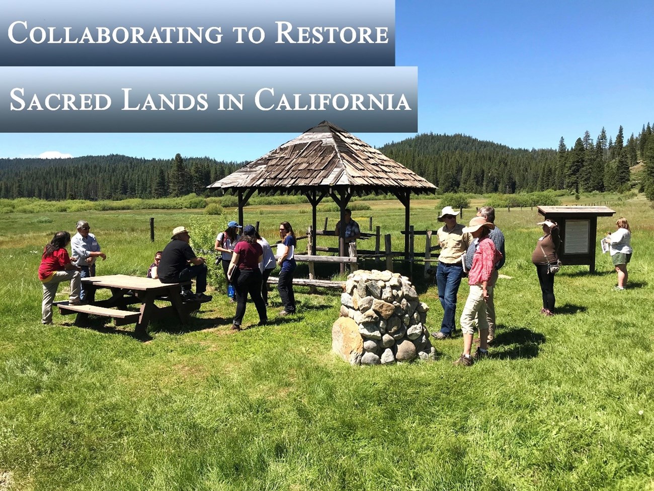 Group of people standing around an interpretive site. NPS Photo