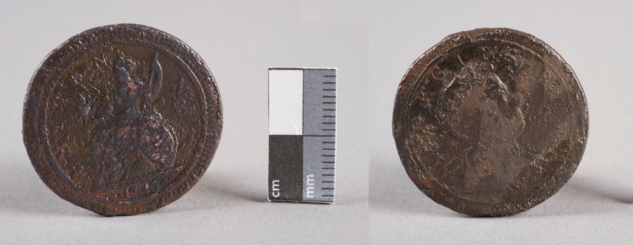 Front and back of an old brass corroded coin, about a half inch across.