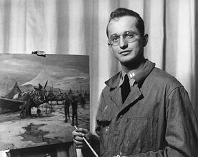 Black and white photo of a man holding a paintbrush, standing beside an easel with a painting of a plane on it.