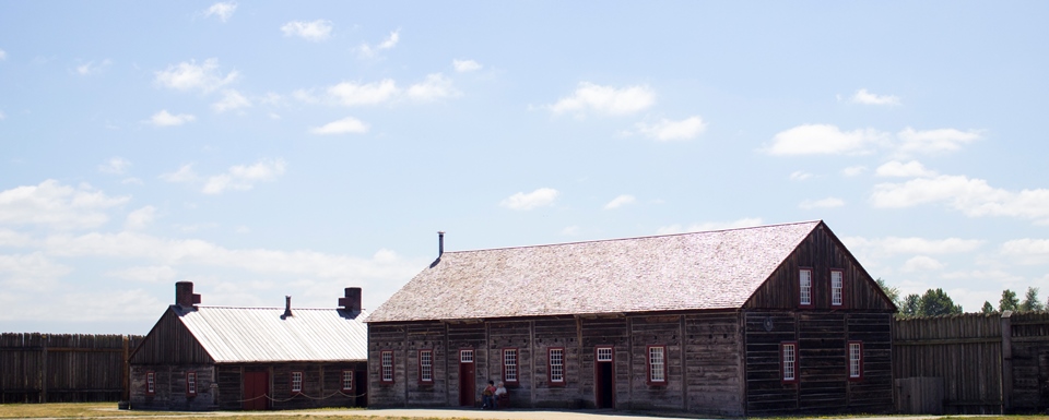 Photo of a wooden rectangular building along the fort's stockade wall