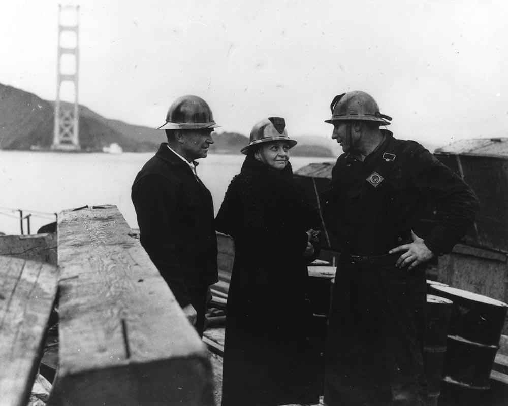 Atop the Golden Gate Bridge: steel crew foreman Grover McClain, Labor Secretary Frances Perkins and welder S.E. Stanley during 1935 bridge construction.