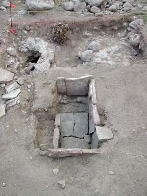 This slab-lined fire box, used for baking food, contained ashy soil and a baking powder can lid. NPS photo.