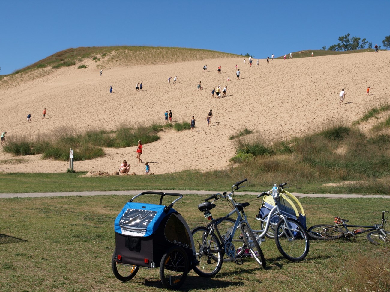 Visitors climb a sand dune at Sleeping Bear Dunes National Lakeshore.