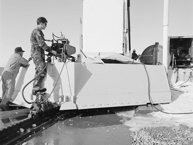Airman works a control on the rear of a blast door