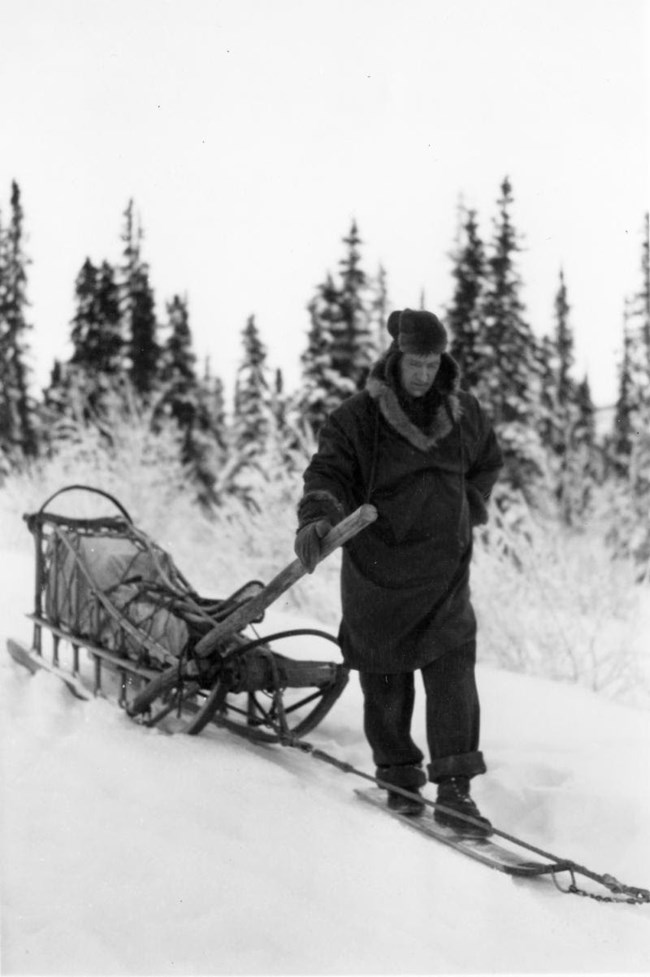 a man pulling a sled in the snow