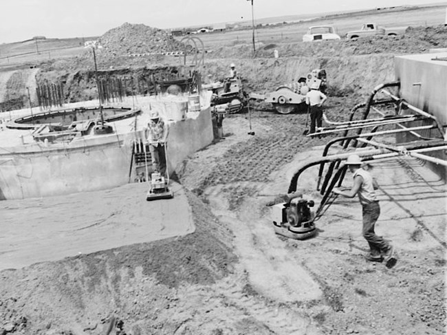 men work at a site with concrete features