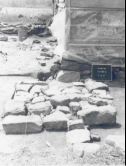 Stone foundation remains of the old Brawner House next to wall of existing house. Building stones fragments are scattered around the site.
