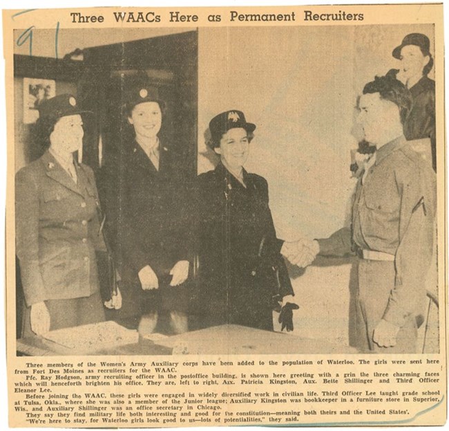 newspaper image of three women in uniform, one shaking the hand of a man in uniform