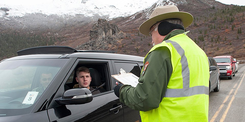 A park rangers talks to visitors in a car