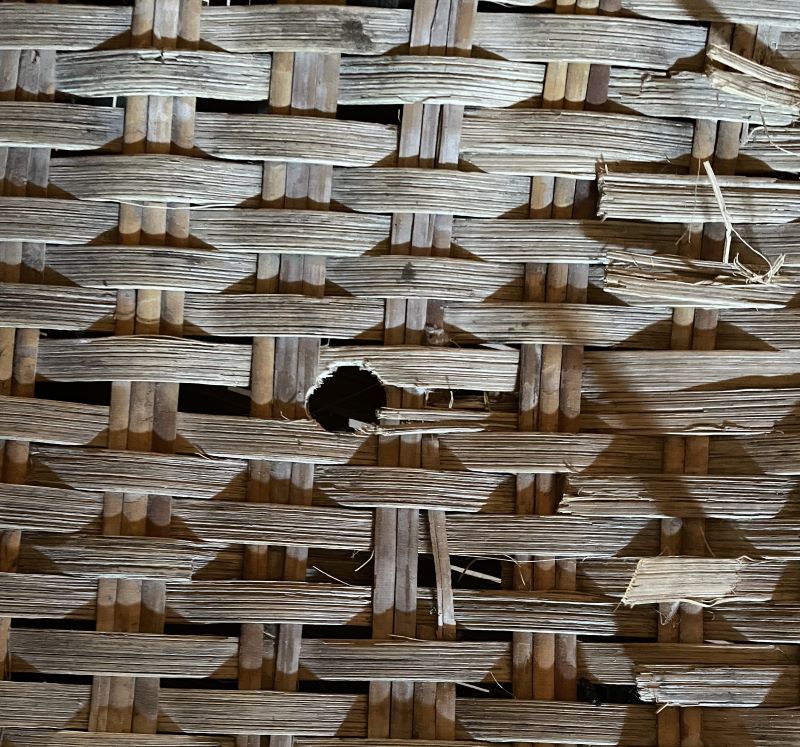 Hole from a mouse in a woven chair seat.