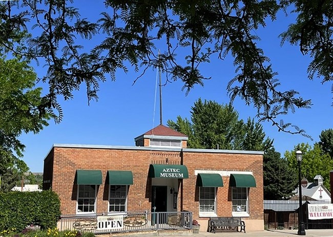 The outside of a brick building with an overhang reading "Aztec Museum"