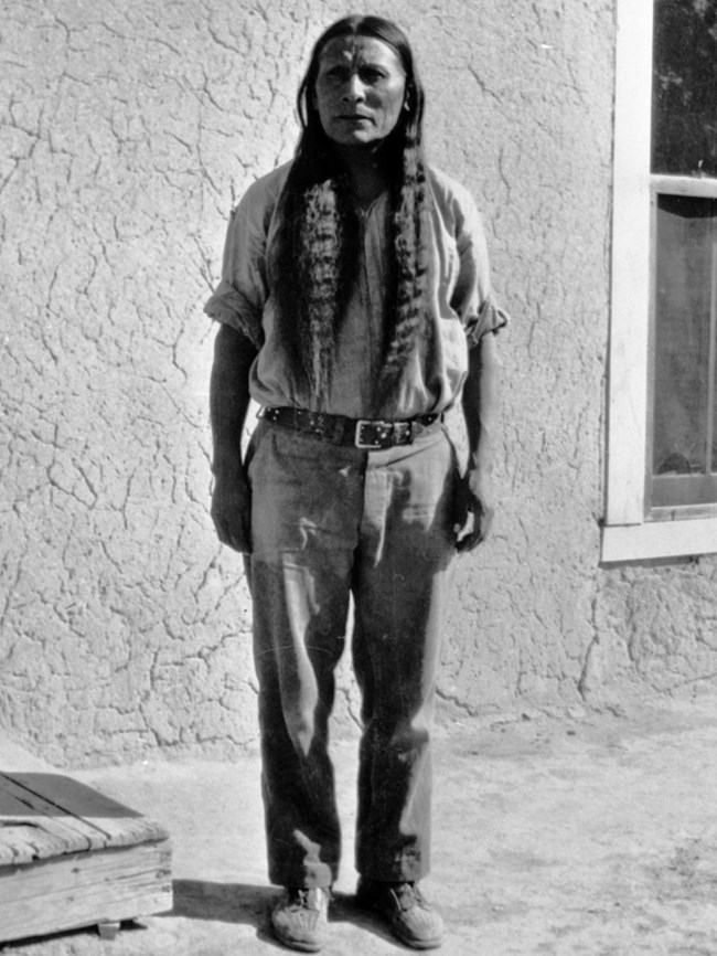 A black and white portrait of a man standing.