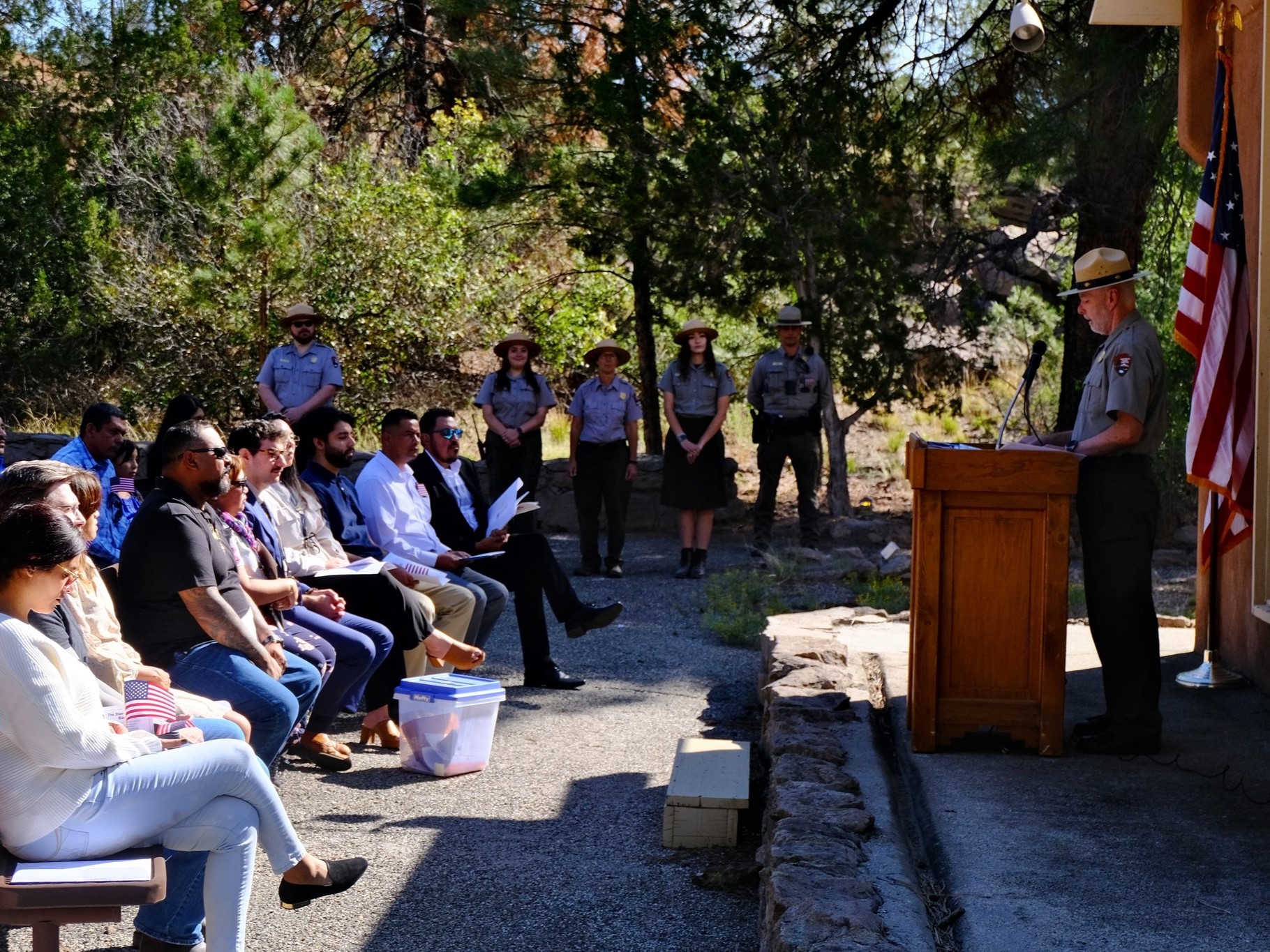 A group of people sitting and facing a park ranger standing at a podium.