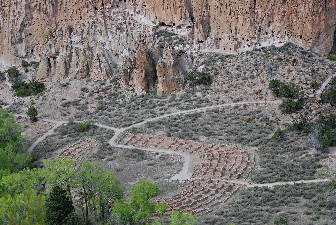 An aerial view of stone building foundations and trails.