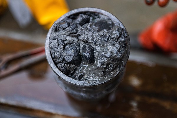 Top view of a round tube with rocks and mud in it.