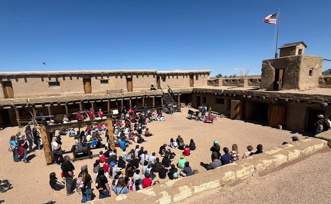 Classes listen to Native American speaker inside fort plaza