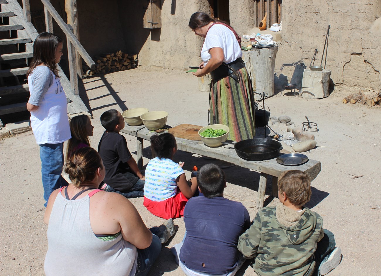 Children watch a costumed volunteer conduct a cooking demonstration